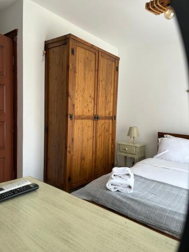 a bedroom with a bed and a wooden cabinet at Pupa Alaçatı Butik Otel in Cesme