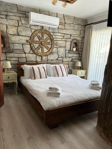a bedroom with a large bed with a stone wall at Pupa Alaçatı Butik Otel in Cesme