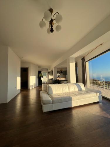 - une chambre avec un lit blanc et une grande fenêtre dans l'établissement Apartment Nave, à Ičići