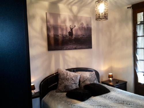 - une chambre avec un lit et une photo de cerf dans l'établissement Appartement cosy à Villeneuve avec jardin privé, à Villeneuve-dʼAveyron
