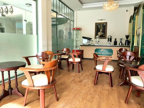 un groupe de tables et de chaises dans un restaurant dans l'établissement Le Petit Paris Dalat Hotel, à Đà Lạt