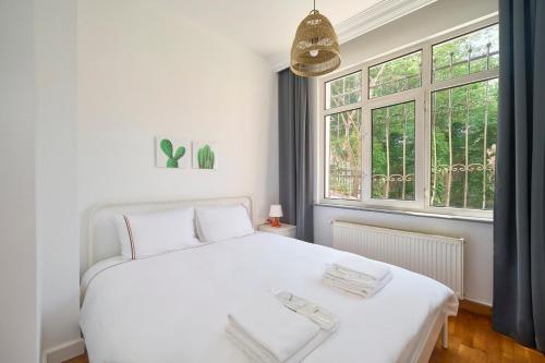 ein Schlafzimmer mit einem weißen Bett und einem Fenster in der Unterkunft Cozy Cute 1 Bed1bath Bebek Private Terrace! #75 in Istanbul