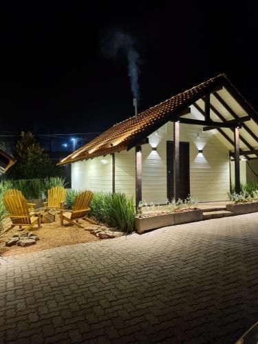 a white building with two chairs and a table at Chalés De Cambará in Cambara do Sul
