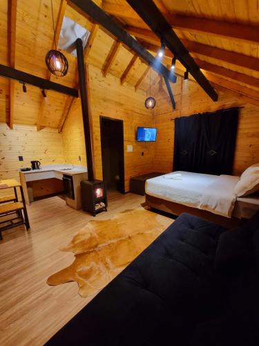 a bedroom with a bed and a desk in a room at Chalés De Cambará in Cambará