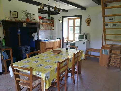 une cuisine avec une table et un chiffon de table jaune dans l'établissement La Petite Maison Pont Blanchard,, à Pléaux