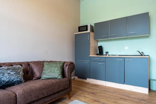 a living room with a couch and a kitchen at Moselresidenz Bellevue Alf Apartment Moselblick in Alf