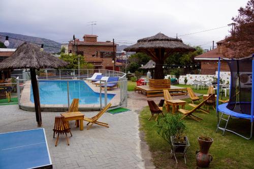 a pool with chairs and tables and umbrellas at Nuevo Suiza Hotel in Villa Carlos Paz