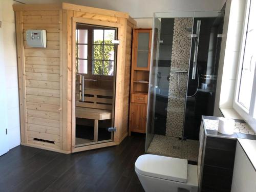 a bathroom with a toilet and a glass shower at Seeliebe mit Sauna und nur 50 mtr. bis zum Strand in Senftenberg