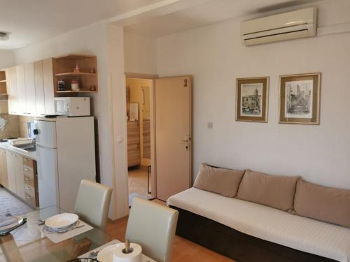 ein Wohnzimmer mit einem Sofa und einer Küche in der Unterkunft Near by everything in Vodice