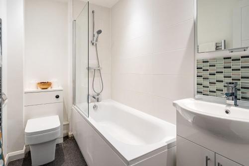 Baño blanco con aseo y lavamanos en Contemporary City Centre Apartment With Parking, en Bath