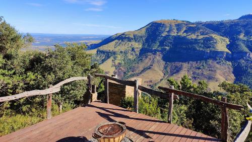 a wooden deck with a view of a mountain at The Edge Mountain Retreat in Hogsback