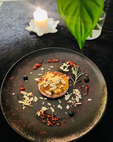 a black plate with a candle and some food on it at Piano in Nowy Sącz