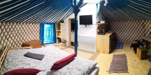 um quarto com uma cama e um tecto azul em Jurta na zvířecí farmě 