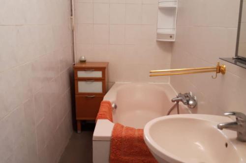 une salle de bain avec un lavabo et une baignoire dans l'établissement Bel appartement dans un magnifique domaine du XVIe, à Autouillet