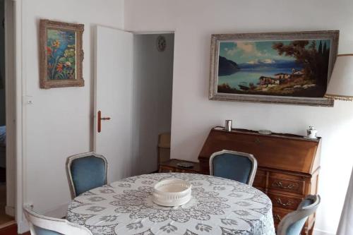 une salle à manger avec une table et des chaises et un tableau dans l'établissement Bel appartement dans un magnifique domaine du XVIe, à Autouillet