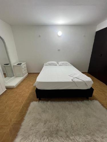 Un dormitorio con una cama y una alfombra. en Casa completa al frente del centro comercial alamedas en Montería