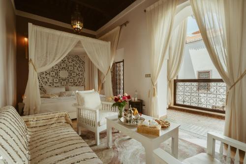 uma sala de estar com um sofá e uma cama em Riad Dar Dialkoum em Marrakech