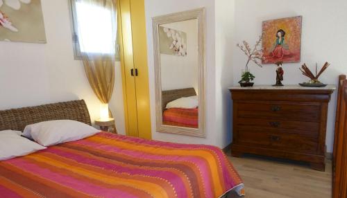 une chambre avec un lit, une commode et un miroir dans l'établissement T2 ensoleillé, vue mer et champ, climatisé, à Carqueiranne