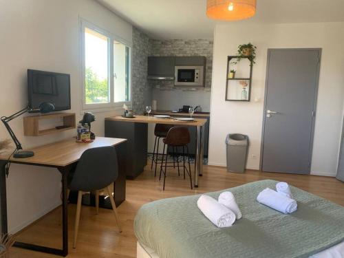 Cette chambre comprend un lit, un bureau et une cuisine. dans l'établissement Le Wild, Superbe studio au bord de la vilaine, à Rennes