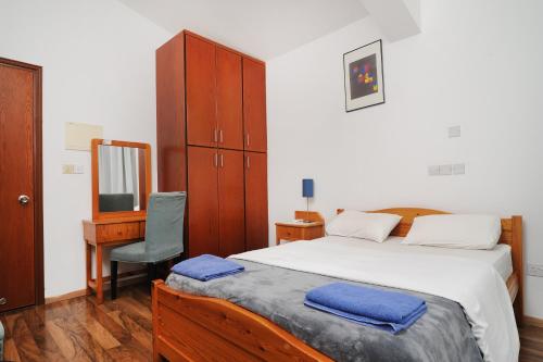 a bedroom with a bed and a desk and a mirror at Bella Rosa hotel Cyprus in Coral Bay