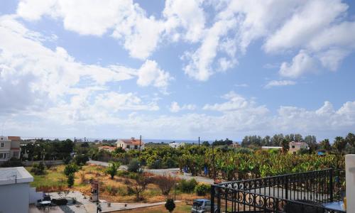 a view from a balcony of a town with trees at Bella Rosa hotel Cyprus in Coral Bay