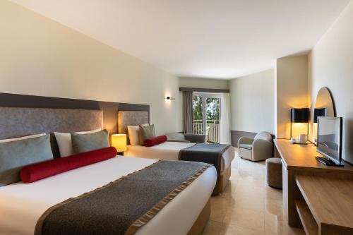 Habitación de hotel con 2 camas y TV en Paloma Perissia, en Side