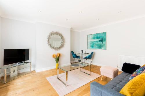 a living room with a blue couch and a table at Boutique Basement 1 Bed Flat, central location, free parking, Wi-Fi, Sky, Netflix in Leamington Spa