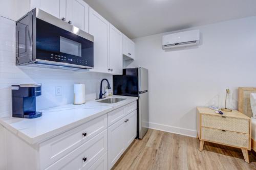 a kitchen with white cabinets and a sink at Boho Flamingo Studio Apartment in Galveston