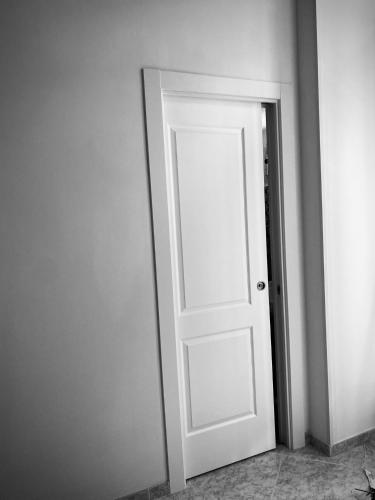 a white door in the corner of a room at AVòS in Polignano a Mare