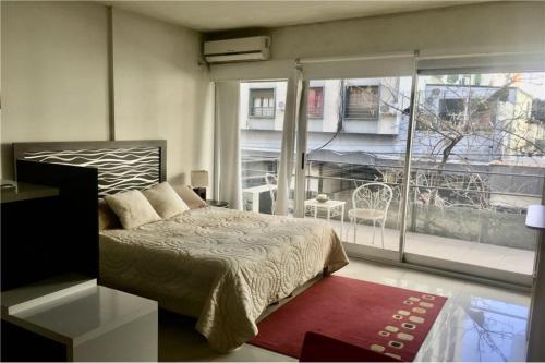 1 dormitorio con cama y ventana grande en Excellent Studio in Palermo Soho with Fast WIFI en Buenos Aires