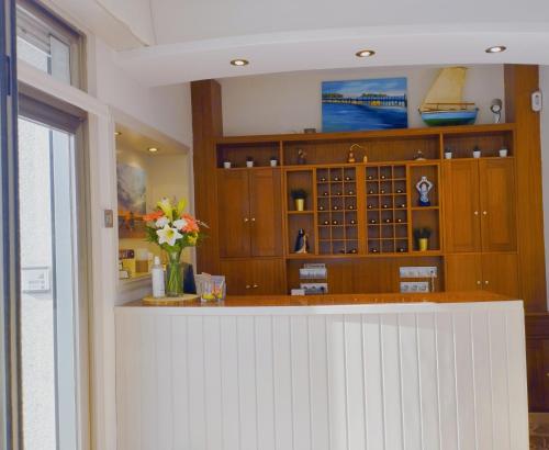 una cocina con armarios de madera y una barra con flores en Hotel Argibay, en O Grove