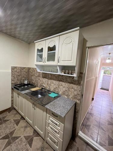 a kitchen with white cabinets and a counter top at Linda Guest house in Batumi