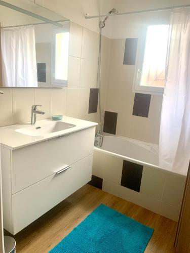 a white bathroom with a sink and a bath tub at Villa Le Faré 10 min des plages - Climatisée - 8 Pers - Piscine Chauffée du 1er Juin au 15 sept - in Azur