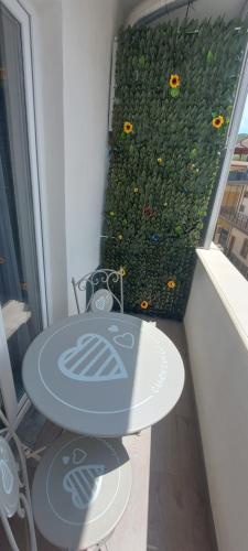 a table and chairs in front of a wall with flowers at Clausis in Parghelia