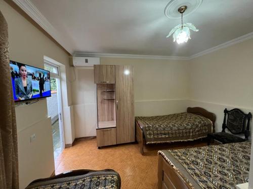 a room with two beds and a flat screen tv at Linda Guest house in Batumi
