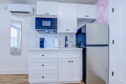 een keuken met witte kasten en een koelkast bij Pink Flamingo Studio Apartment in Galveston