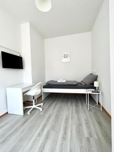 Zimmer mit einem Bett, einem Schreibtisch und einem TV in der Unterkunft Monteurzimmer in zentraler Lage in Emden