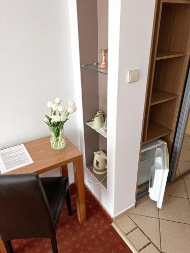 a room with a table and a vase of flowers at Willa Milano in Mielno