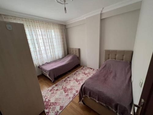 een kleine slaapkamer met 2 bedden en een tapijt bij Очень уютная квартира 2+1 in Antalya