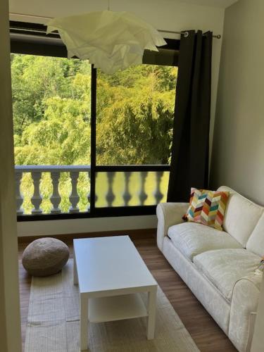 a living room with a couch and a table and a window at L'AUBERGE DE LA GOUTILLE in Capvern