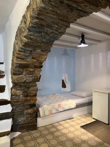 a bed in a room with a stone wall at Cellar Falatados in Mési