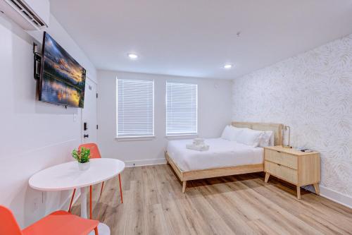 1 dormitorio con 1 cama, mesa y sillas en Tiger Motel Studio Apartment en Galveston