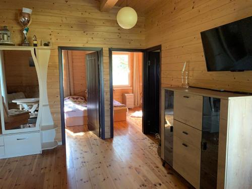 un salon avec une télévision et une chambre dans l'établissement Pociunai relax house, à Pociūnai