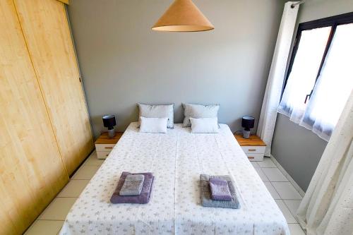 une chambre avec un grand lit blanc avec deux oreillers dans l'établissement Regard sur les remparts - Terrasse & Parking, à Avignon