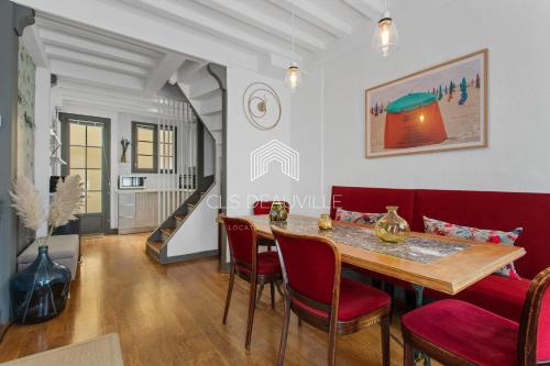 uma sala de jantar com uma mesa e cadeiras vermelhas em Maison de Pêcheur La Coquette CLS Deauville em Trouville-sur-Mer