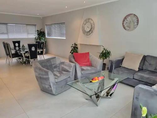 a living room with a couch and chairs and a table at Colourful Horizons in Germiston