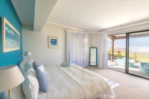 ein Schlafzimmer mit großem Bett und Balkon in der Unterkunft The Beauty of The Wildside 3 bedroom in Cape St Francis