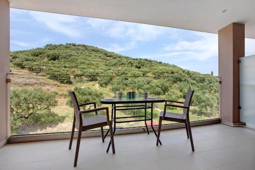 a table and chairs in a room with a large window at Villa Dionysia Studio S6 in Alikanas