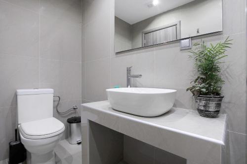 a white bathroom with a sink and a toilet at Villa Dionysia Studio S6 in Alikanas