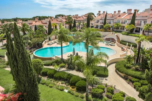 una vista aérea de una piscina del complejo con palmeras en Luxury Apartment with Communal Pool and Terrace en Quarteira